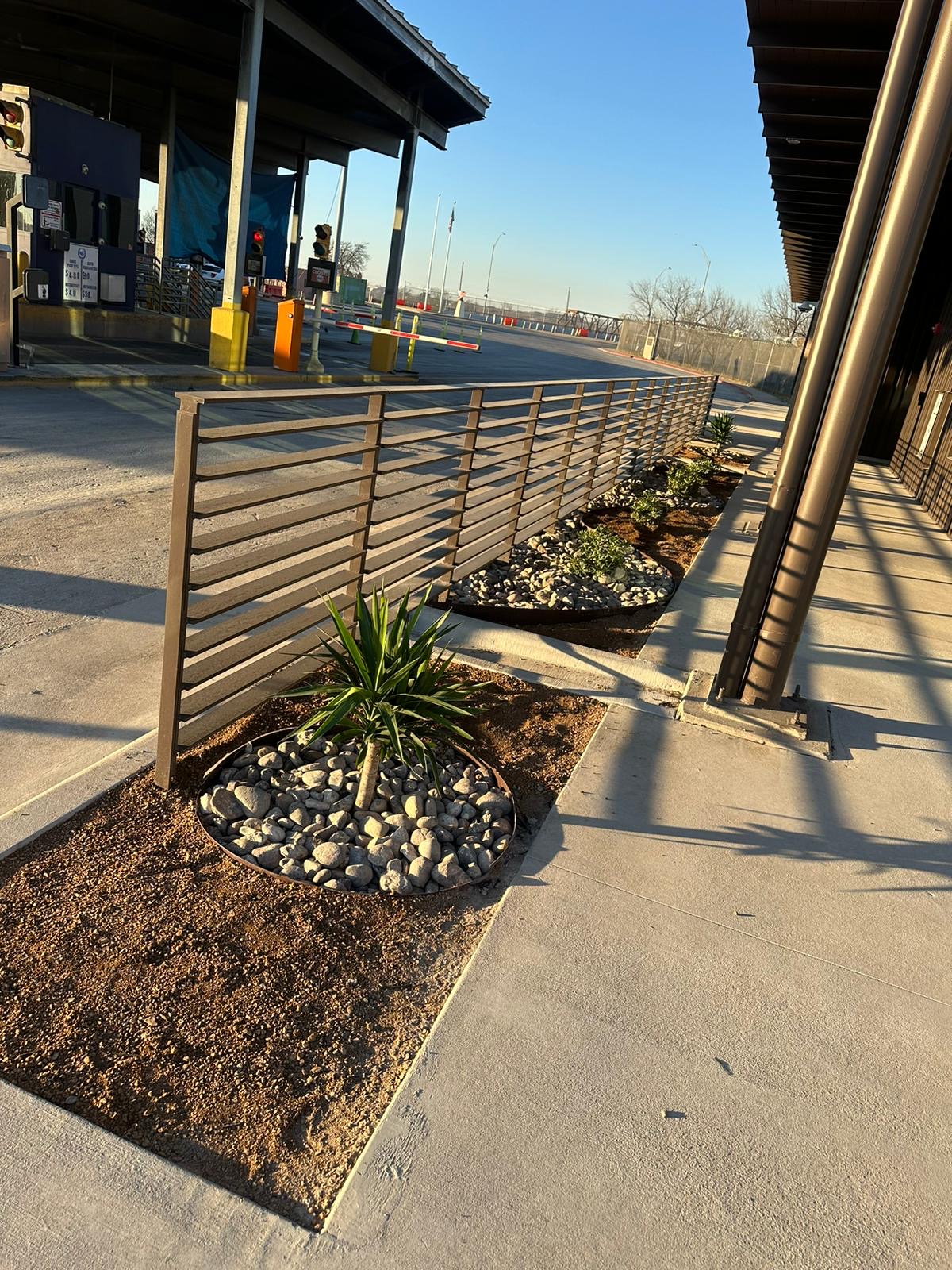 Long row of landscaped rock border beds along a commercial facility